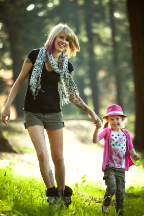 Mother with tattoo walking child in woods
