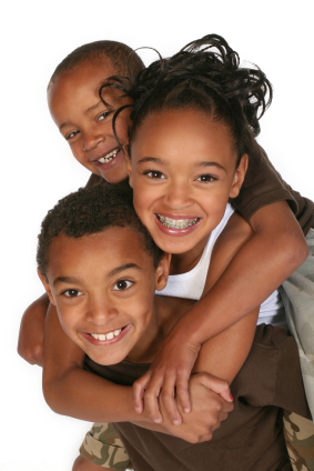 Three kids one with braces holding each other