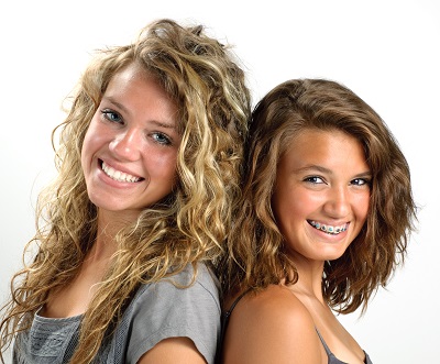 Two teenage girls one with braces smiling